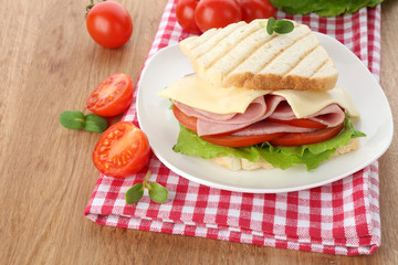 Tasty sandwich with ham on wooden table