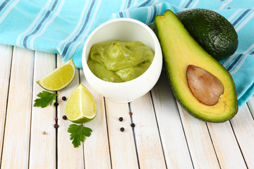 Fresh guacamole in bowl on wooden table © Africa Studio