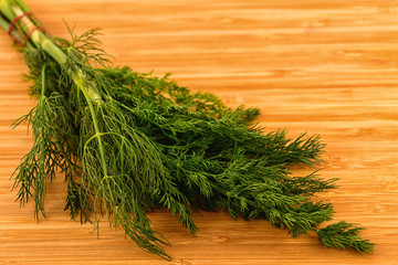 Bunch of fresh green dill on a wooden board.
