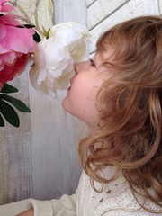 Beautiful girl smelling flowers