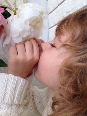 Beautiful girl smelling flowers