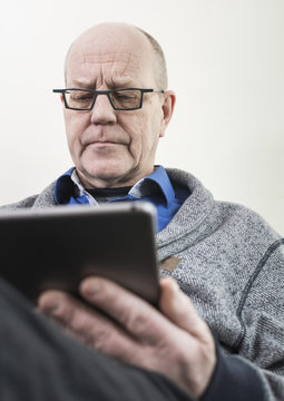 Old man on tablet pc.