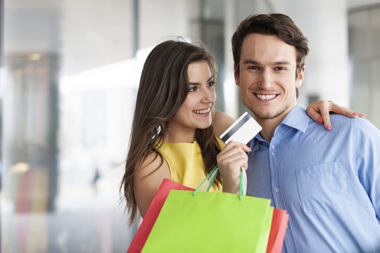 Fashion couple with credit card and shopping bags