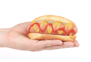Hand holds big hotdog.