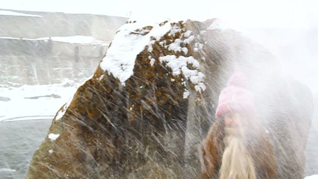 Young girl walking in winter snow falls