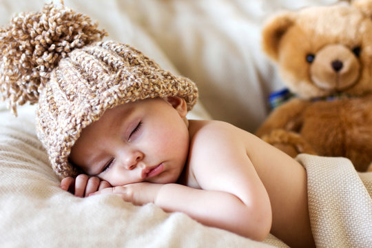 Little baby boy, sleeping with teddy bear