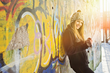 Beautiful happy teenage girl using tablet computer outdoors
