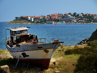 old, damaged boat on the shore in Ammouliani - obrazy, fototapety, plakaty