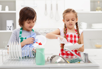 Kids washing the dishes in the kitchen