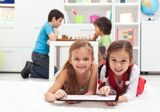 Kids playing classic board games and modern tablet computer game