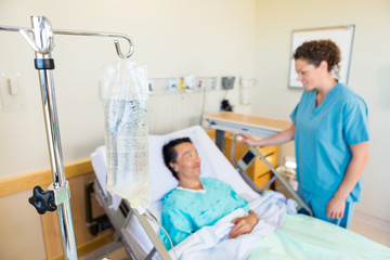 IV Bag With Nurse And Patient Looking At Each Other