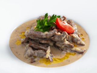Delicious hot beef stroganoff with cream sauce served on a white
