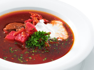 Delicious ukrainian borscht served on a white plate. Hot soup wi