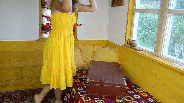 rural room on bed lie large suitcase girl takes yellow hat