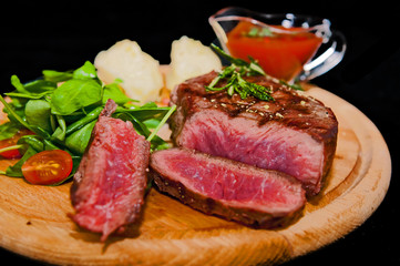 Grilled steak with potatoes, salad and ketchup