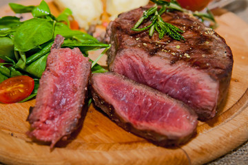 Grilled steak with potatoes, salad and ketchup