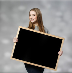 student female holding a chalkboard at light background