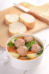 Meatball soup in a white bowl
