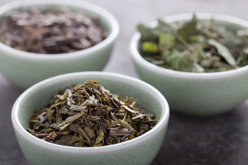 Different sorts of green tea in a green cup. Selective focus.