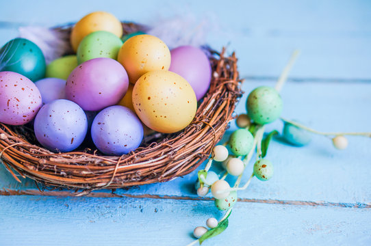 Easter eggs in the nest on blue wooden background