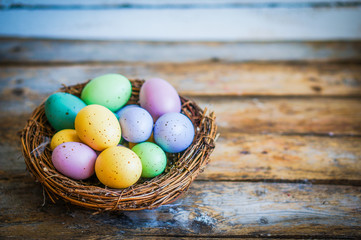 Easter eggs in the nest on rustic wooden background
