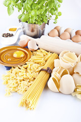 Italian pasta, eggs and rolling pin on a white background