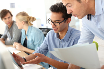 Young man in business training school with teacher