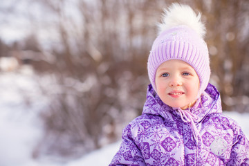 Portrait of Little cute happy girl having fun in the snow on a