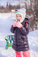 Little adorable happy girl in the snow sunny winter day