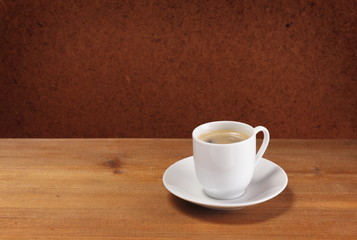 Coffee cup and saucer on wooden table