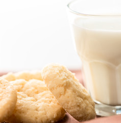 Cookies and milk in glass on napkin close up