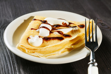 Closeup of chocolate pancakes with whipped cream