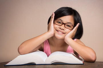 Girl wearing glasses reading at home