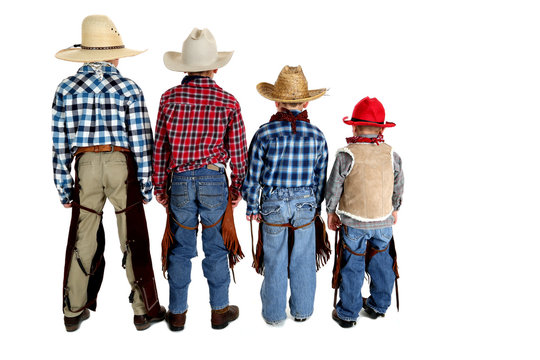 View of the backs of four young cowboys looking away
