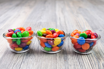 Three glass bowls with multicolored candies