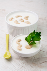 Two bowls with smooth white cream and cashew nuts