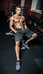 Fototapeta na wymiar Bodybuilder in a fitness gym sitting