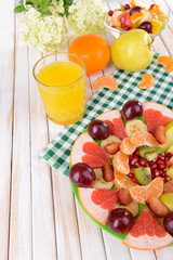 Sweet fresh fruits on plate on table close-up