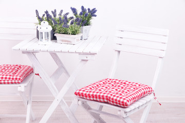 Garden chairs and table with flowers on white background