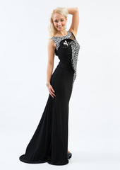 Fototapeta premium Beautiful female fashion model posing in black dress