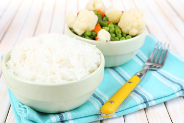 Cooked rice with vegetables on wooden table close up