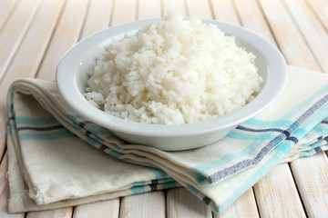 Cooked rice in bowl on wooden background