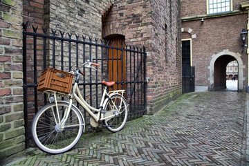 Fototapeta na wymiar White bicycle near the lattice in Binnenhof, Hague, Netherlands