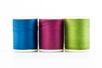 Three spools of sewing thread