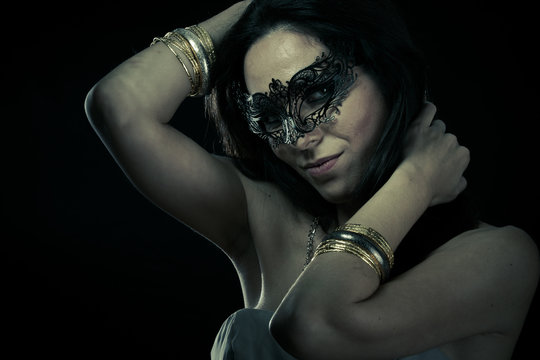 Tribal.Beautiful young woman in mysterious black Venetian mask.