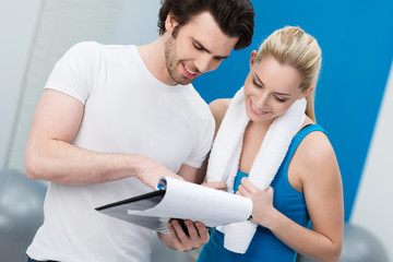 trainer bespricht fitnessplan mit kundin