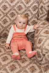 Fototapeta premium portrait of toddler girl sitting on armchair