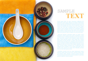 ceramic bowls with spices and rice on color placemat with sample