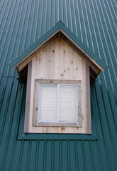 dormer with windows on the dark green roof