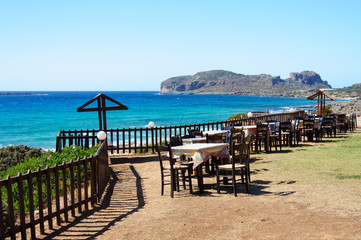 Table and chairs of a Greek taverna on the sea coast